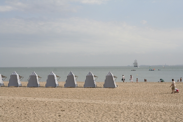 The beach of Royan. The old sailing ship on the horizon was a visitor of the Tour de France for sailing boats. How they get over the Alps is a mystery to me. (For Daphne: beach with blue-white striped tents)